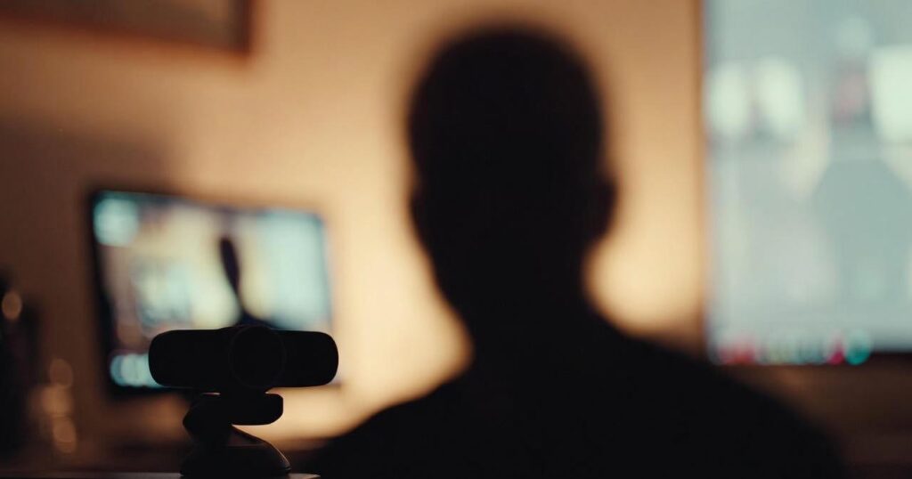 man in a dim room about to start a video chat